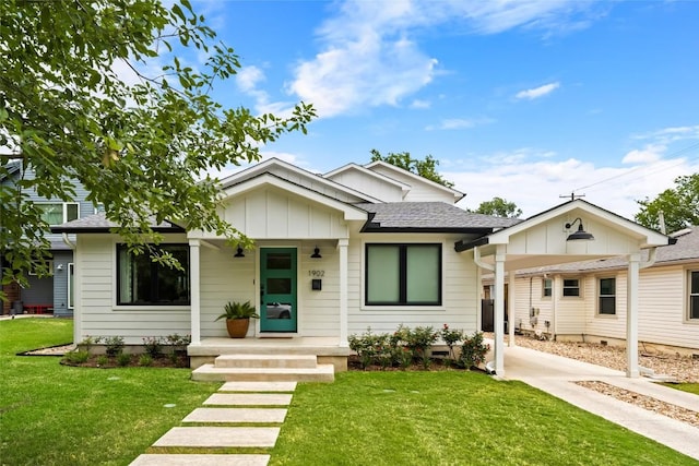 view of front of home with board and batten siding, covered porch, a shingled roof, and a front lawn