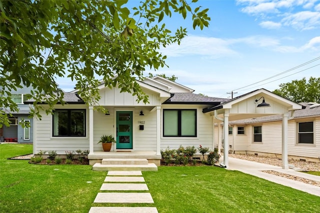 bungalow-style house with board and batten siding, a porch, a front yard, and roof with shingles