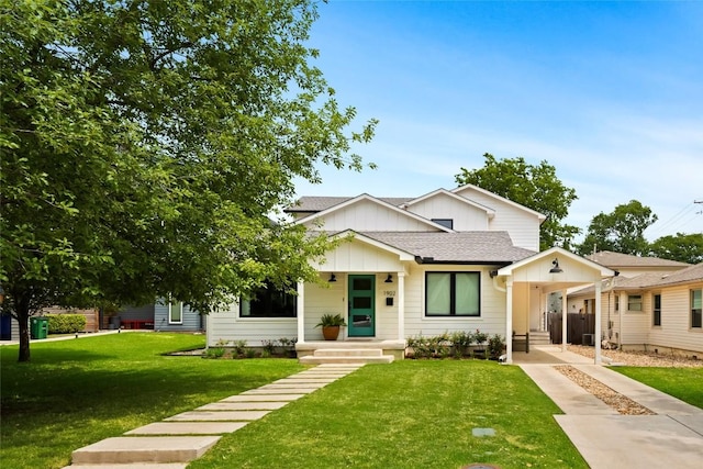 bungalow-style home featuring a shingled roof, board and batten siding, and a front yard