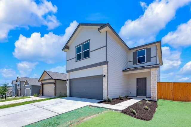 200 Lucky Texan Rd, Jarrell, TX 76537 - view of front of home with concrete driveway, an attached garage, and stone siding