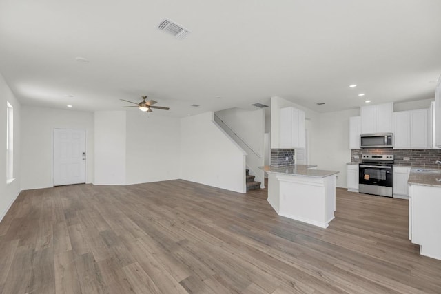 200 Lucky Texan Rd, Jarrell, TX 76537 - kitchen with appliances with stainless steel finishes, open floor plan, decorative backsplash, recessed lighting, and light wood-style floors