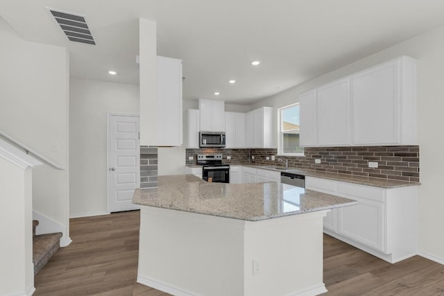 200 Lucky Texan Rd, Jarrell, TX 76537 - kitchen featuring stainless steel appliances, light stone counters, tasteful backsplash, light wood-type flooring, and recessed lighting
