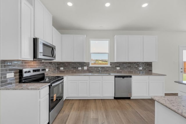 200 Lucky Texan Rd, Jarrell, TX 76537 - kitchen with stainless steel appliances, light stone counters, light wood-style floors, and recessed lighting