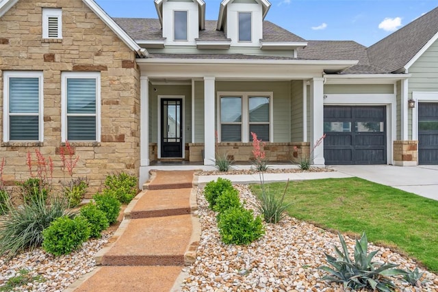 view of front of property with an attached garage, driveway, covered porch, and stone siding