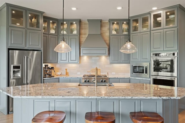 kitchen with appliances with stainless steel finishes, tasteful backsplash, custom range hood, and recessed lighting