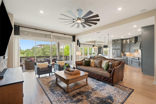 living room featuring ceiling fan, recessed lighting, and light wood-style flooring