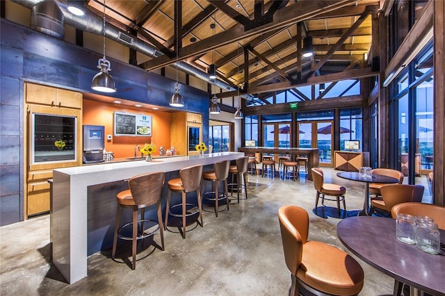bar featuring high vaulted ceiling, a community bar, finished concrete floors, wine cooler, and wood ceiling
