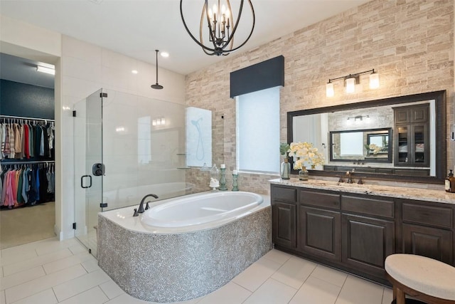 bathroom featuring a garden tub, tile patterned flooring, a stall shower, vanity, and an inviting chandelier