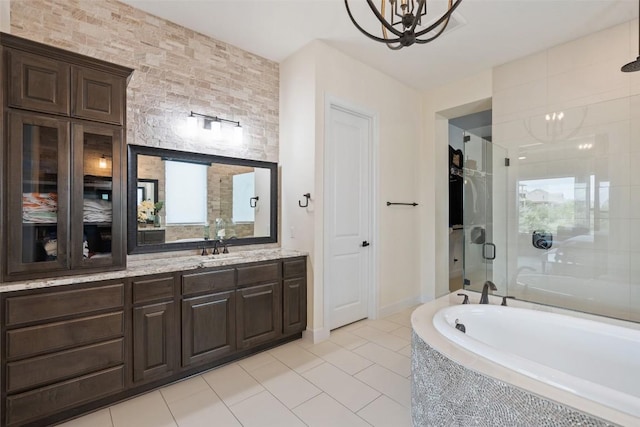 bathroom with tile patterned flooring, a notable chandelier, a garden tub, and a stall shower