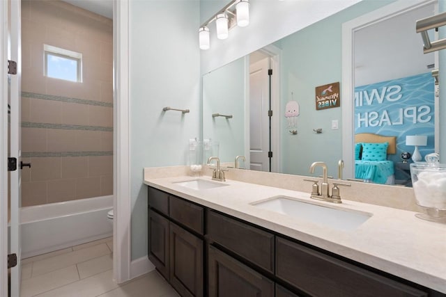 full bath with ensuite bathroom, a sink, tile patterned flooring, and double vanity