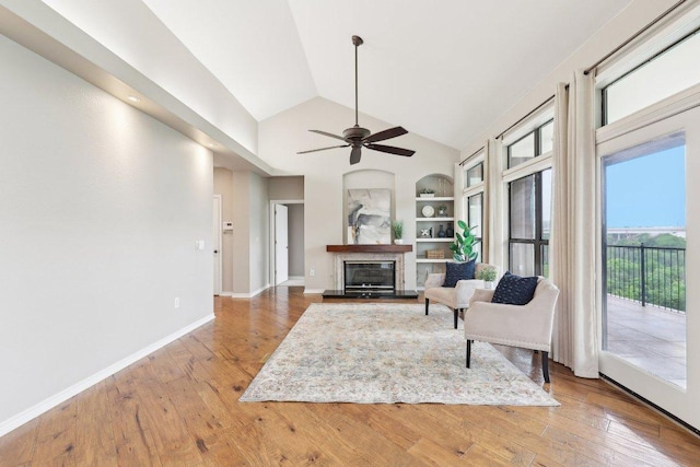 300 San Gabriel Village Blvd Unit 721, Georgetown, TX 78626 - sitting room with built in shelves, a glass covered fireplace, hardwood / wood-style flooring, high vaulted ceiling, and ceiling fan
