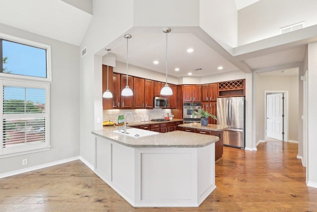 300 San Gabriel Village Blvd Unit 721, Georgetown, TX 78626 - kitchen with stainless steel appliances, a sink, light wood-type flooring, tasteful backsplash, and a center island