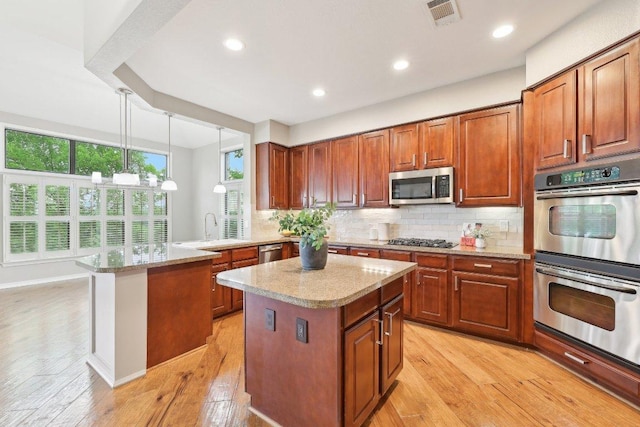 300 San Gabriel Village Blvd Unit 721, Georgetown, TX 78626 - kitchen featuring appliances with stainless steel finishes, a sink, a center island, a peninsula, and backsplash