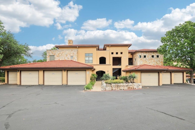 300 San Gabriel Village Blvd Unit 721, Georgetown, TX 78626 - mediterranean / spanish house with community garages, stucco siding, a chimney, and a tile roof