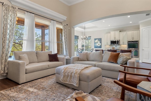 living area with crown molding, recessed lighting, a chandelier, and dark wood finished floors