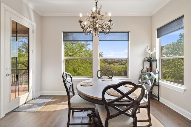 dining room featuring crown molding, baseboards, an inviting chandelier, and wood finished floors