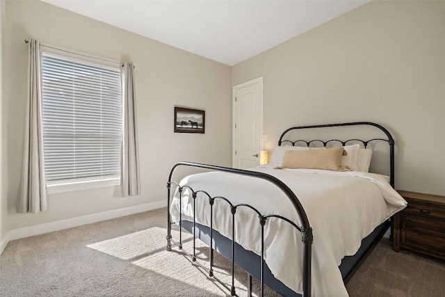 carpeted bedroom featuring baseboards and multiple windows