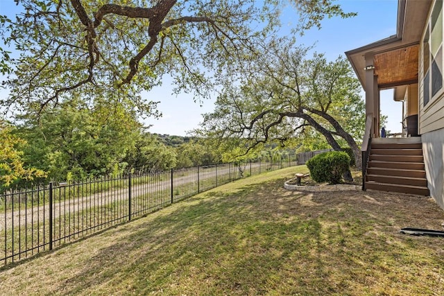view of yard featuring a fenced backyard and stairs