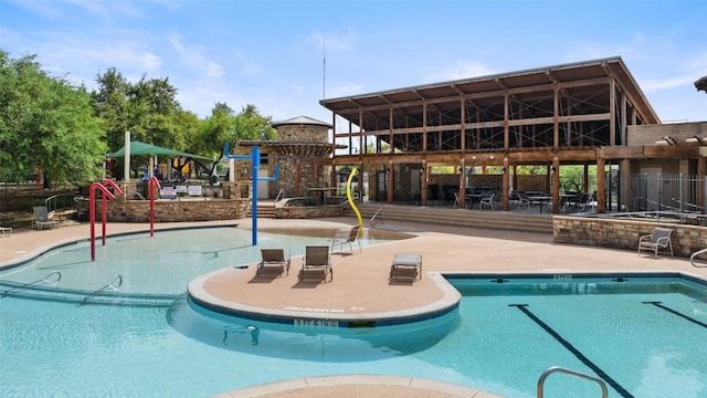 community pool featuring a patio and playground community