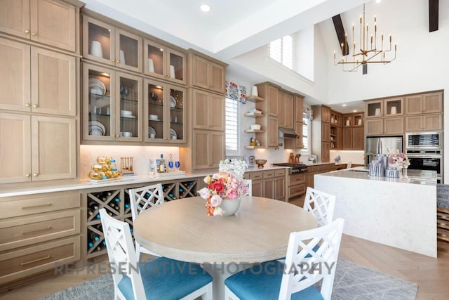 dining area with an inviting chandelier and a high ceiling