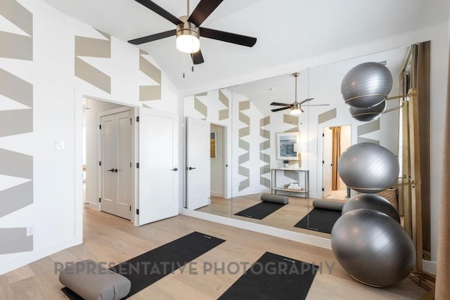 exercise area with high vaulted ceiling, a ceiling fan, and light wood-style flooring