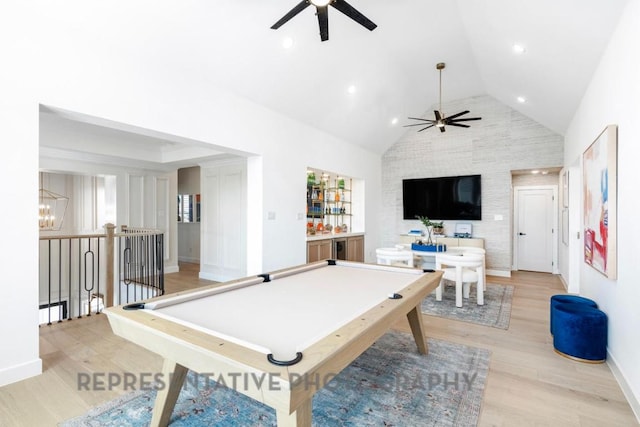 game room with baseboards, light wood finished floors, ceiling fan with notable chandelier, and high vaulted ceiling