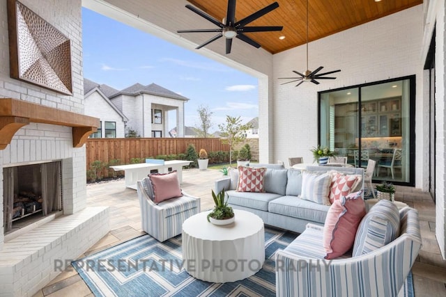 view of patio / terrace featuring fence, a ceiling fan, outdoor dining area, and an outdoor living space with a fireplace