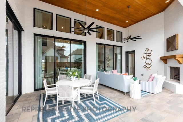 view of patio featuring an outdoor living space with a fireplace, outdoor dining space, and ceiling fan