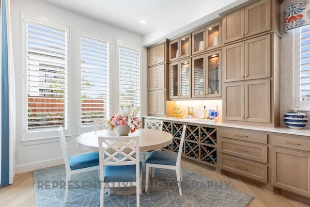 dining area with light wood-style floors, baseboards, and a wealth of natural light