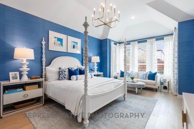bedroom featuring an inviting chandelier, vaulted ceiling, and wood finished floors
