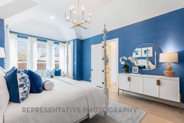 bedroom with a notable chandelier, vaulted ceiling, and wood finished floors