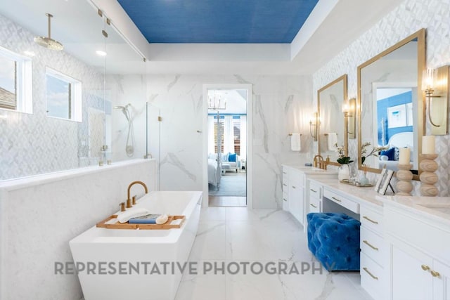 bathroom featuring vanity, ensuite bath, a marble finish shower, a freestanding tub, and tile walls