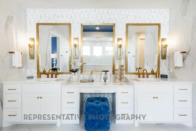 full bath with a sink, wallpapered walls, and double vanity