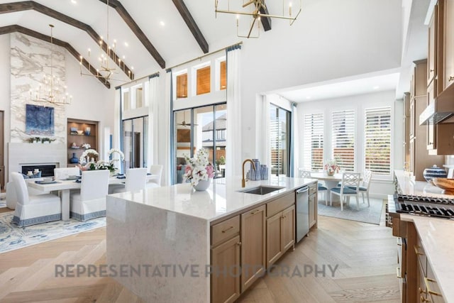 kitchen with a sink, high vaulted ceiling, appliances with stainless steel finishes, and a chandelier