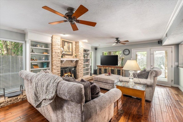10601 Spicewood Pkwy, Austin, TX 78750 - living area with a ceiling fan, a textured ceiling, hardwood / wood-style floors, crown molding, and a stone fireplace