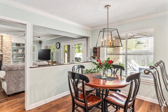 dining room with baseboards, ornamental molding, a textured ceiling, and hardwood / wood-style floors
