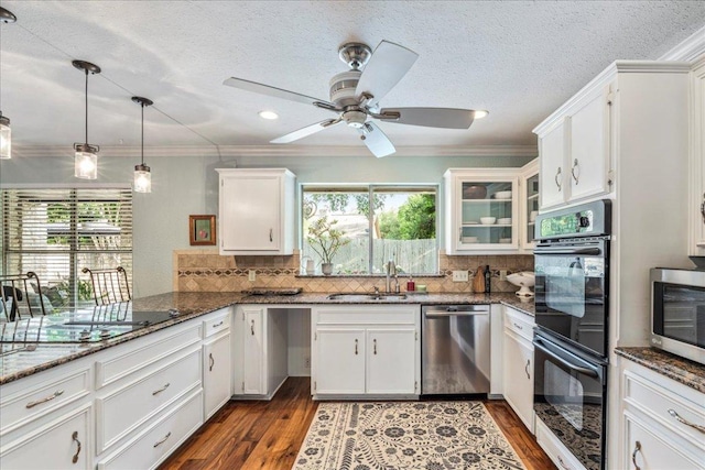 kitchen with white cabinetry, a sink, black appliances, and tasteful backsplash