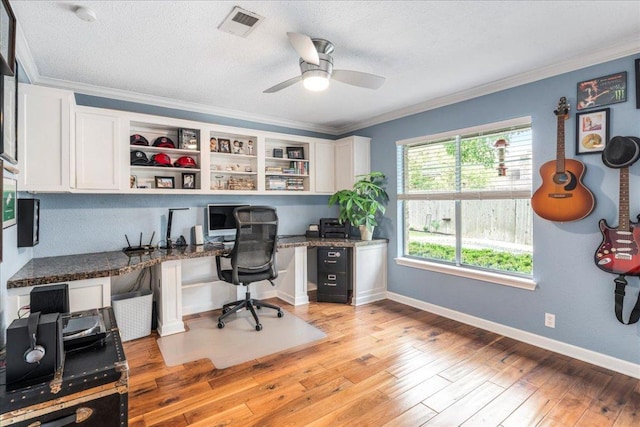 10601 Spicewood Pkwy, Austin, TX 78750 - home office with built in desk, a ceiling fan, light wood finished floors, crown molding, and a textured ceiling