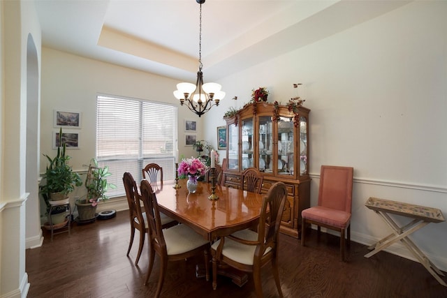 dining area with dark wood finished floors and a chandelier