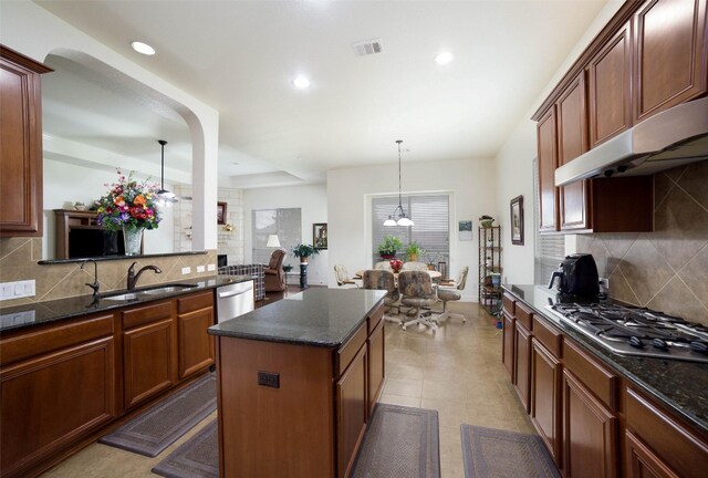 kitchen featuring visible vents, tasteful backsplash, a sink, under cabinet range hood, and stainless steel appliances