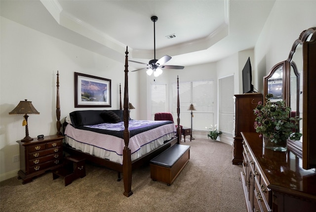bedroom featuring carpet flooring, ceiling fan, a raised ceiling, visible vents, and ornamental molding