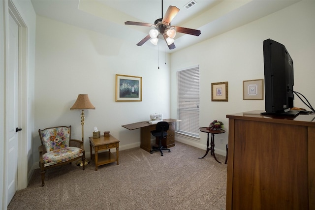 home office with baseboards, visible vents, a ceiling fan, and light colored carpet