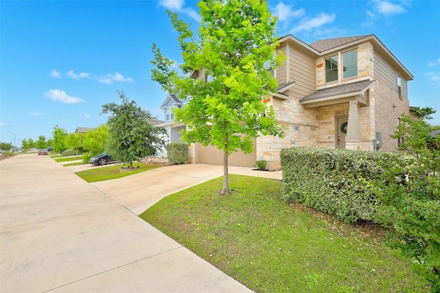 view of front facade with a garage, concrete driveway, a front lawn, and stone siding