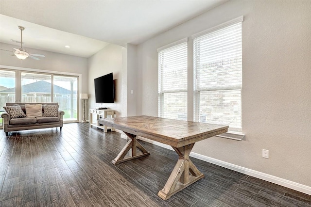 dining room featuring baseboards, ceiling fan, a textured wall, and dark wood-type flooring