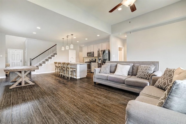 living room with stairs, baseboards, recessed lighting, a ceiling fan, and dark wood finished floors