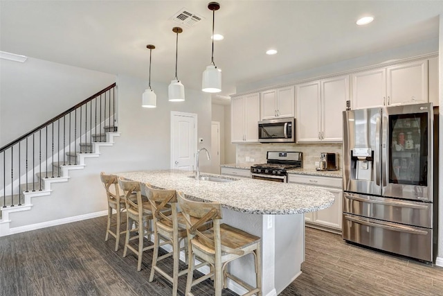 kitchen with visible vents, baseboards, a sink, dark wood finished floors, and stainless steel appliances