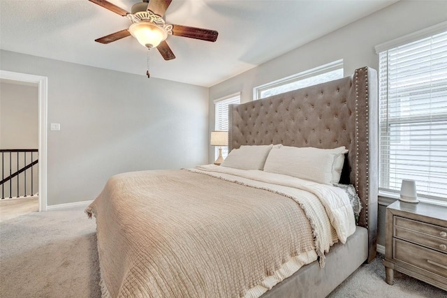 carpeted bedroom featuring baseboards and ceiling fan