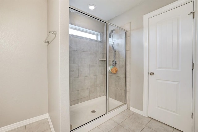 bathroom featuring tile patterned floors, baseboards, and a stall shower