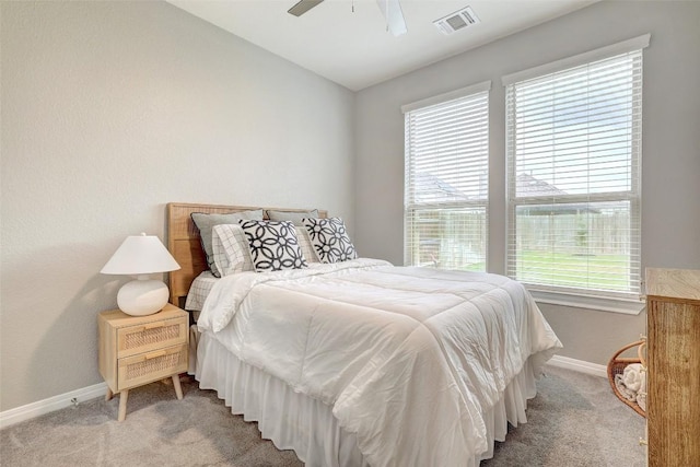 carpeted bedroom with baseboards, multiple windows, vaulted ceiling, and visible vents