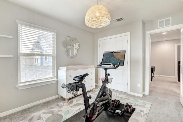 exercise area with visible vents, light carpet, and an inviting chandelier
